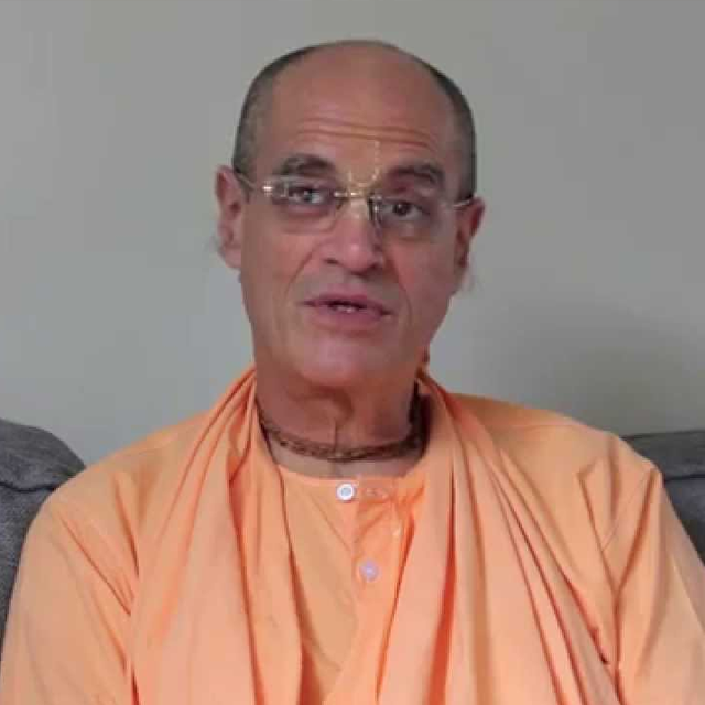 Bir Krishna Das Goswami delivering an inspiring spiritual lecture to devoted followers in a beautifully decorated temple